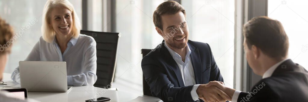 Stretta di mano tra cliente e negoziante soddisfatti del servizio
